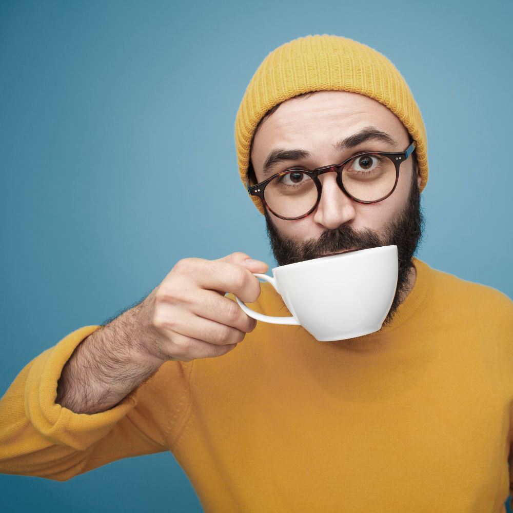 Symbolbild bärtiger junger Mann mit Teetasse